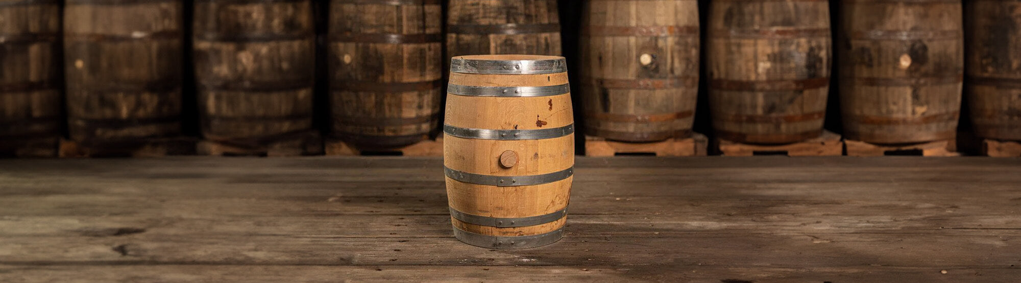freshly emptied 15 gallon barrel with full-size barrels behind it on pallets