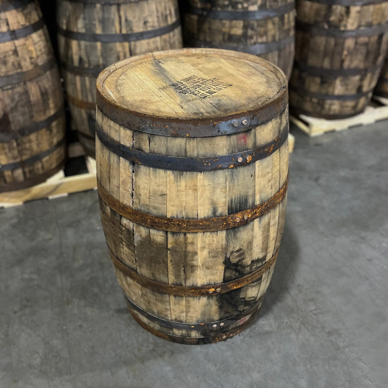 Head and side of a Russell's Reserve Bourbon Single Barrel with head markings, stamps and other used bourbon barrels in the background