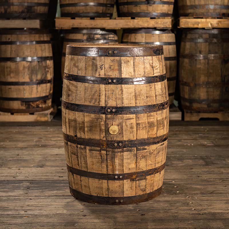 Side of an Old Elk Bourbon barrel with other barrels stacked on pallets in the background