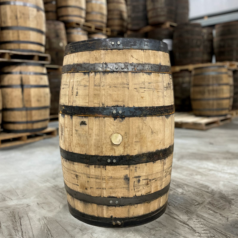 Toasted oak bourbon barrel from Jim Beam Distillery with barrels on pallets in the background
