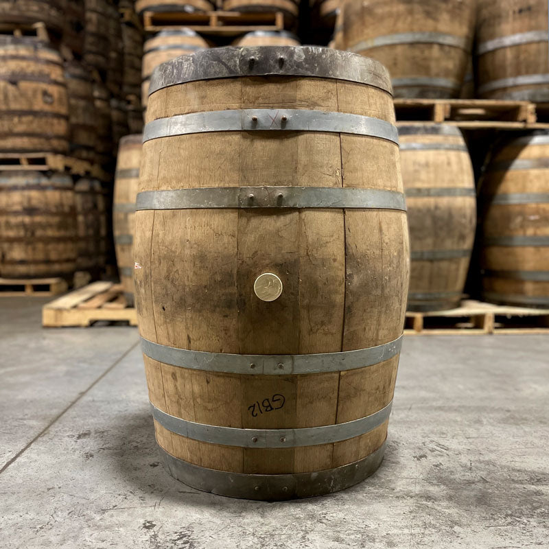Side of a Bardstown Bourbon Plantation Rum Cask Finished Barrel with other barrels stacked on pallets in the background