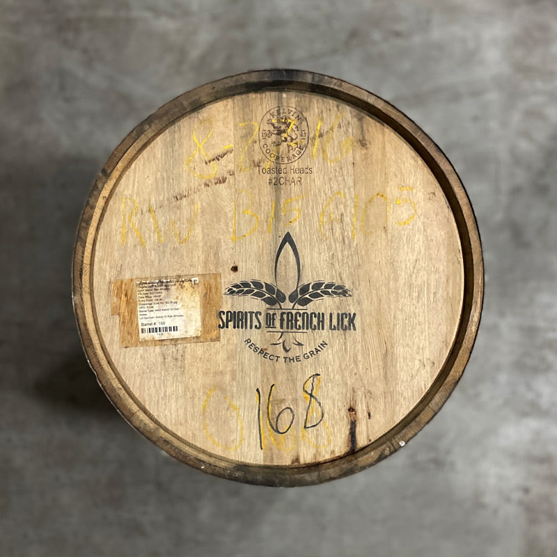 Head of a French Lick Char 2 Rye Whiskey Barrel with a Spirits of French Lick grain logo and slogan "respect the grain" stamped on the head next to a sticker with whiskey info