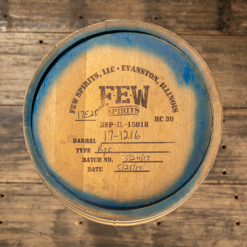 View from above of head of 30 gallon FEW Spirits Rye Whiskey barrel with distillery markings, labeling and a blue stain around the inside edge of the head