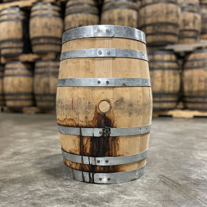 Side with bung of a 15 Gallon West Fork Chocolate Rye Bourbon Barrel and used bourbon barrels in the background