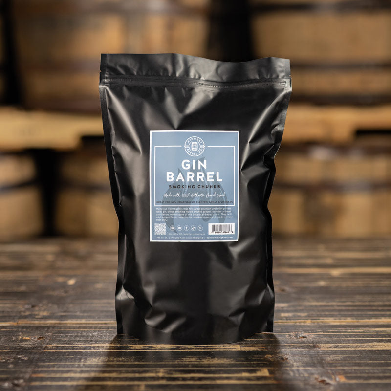 A bag of 100% authentic Gin Barrel Smoking Wood Chunks with used barrels in the background