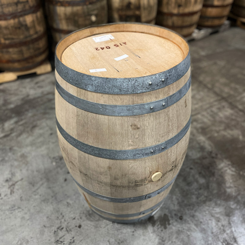 Head and side of a Hangar 1 Grape Brandy Barrel (Ex-Wine) with whiskey barrels in the background