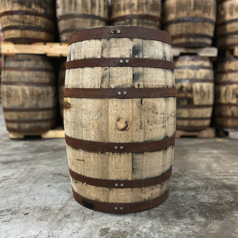 Bung side of a Hangar 1 Grape Brandy Barrel (Ex-Whiskey) with other used whiskey barrels in the background