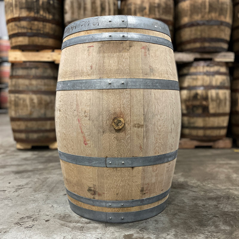 Side with bung of a Hangar 1 Grape Vodka Barrel (Ex-Wine) with used whiskey barrels in the background