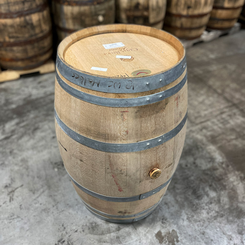 Head and side of a Hangar 1 Grape Vodka Barrel (Ex-Wine) with used whiskey barrels in the background