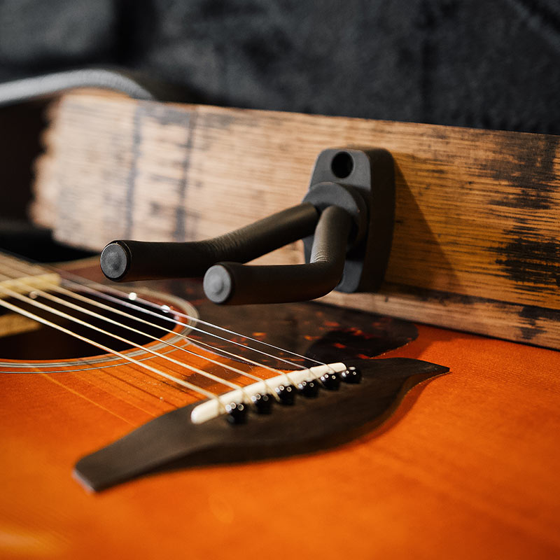 closeup image of barrel stave single guitar hanger and acoustic guitar