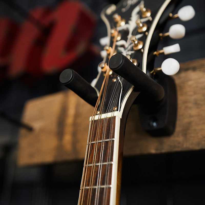 closeup of barrel stave single guitar hanger holding guitar on wall