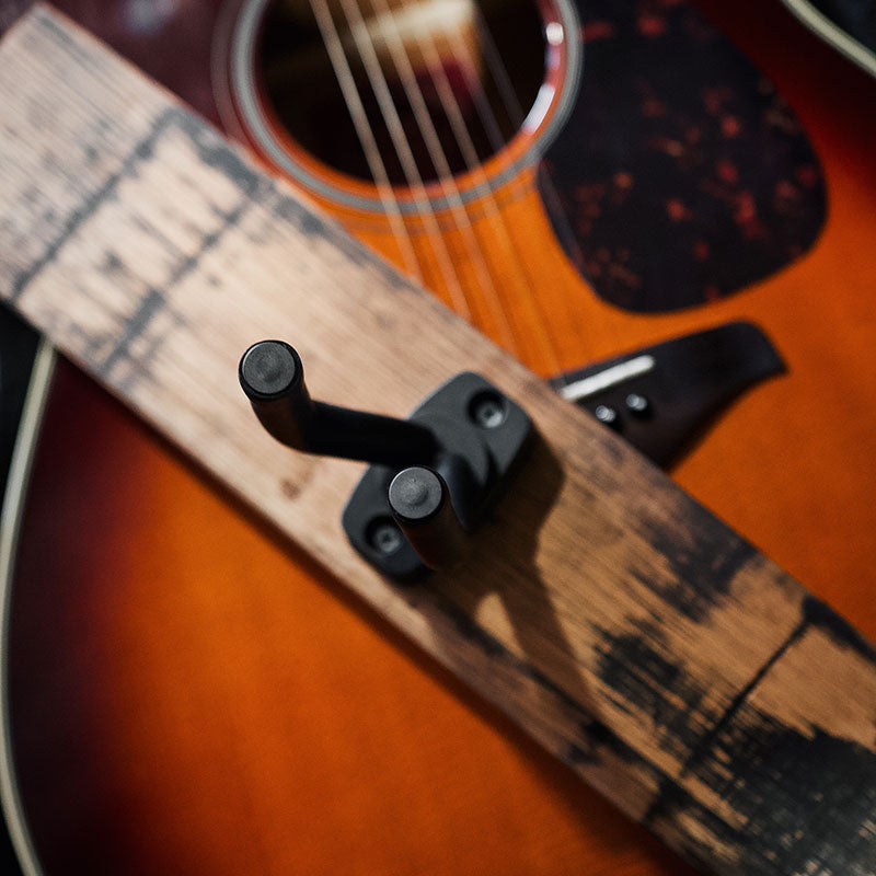 close up of barrel stave single guitar hanger and acoustic guitar