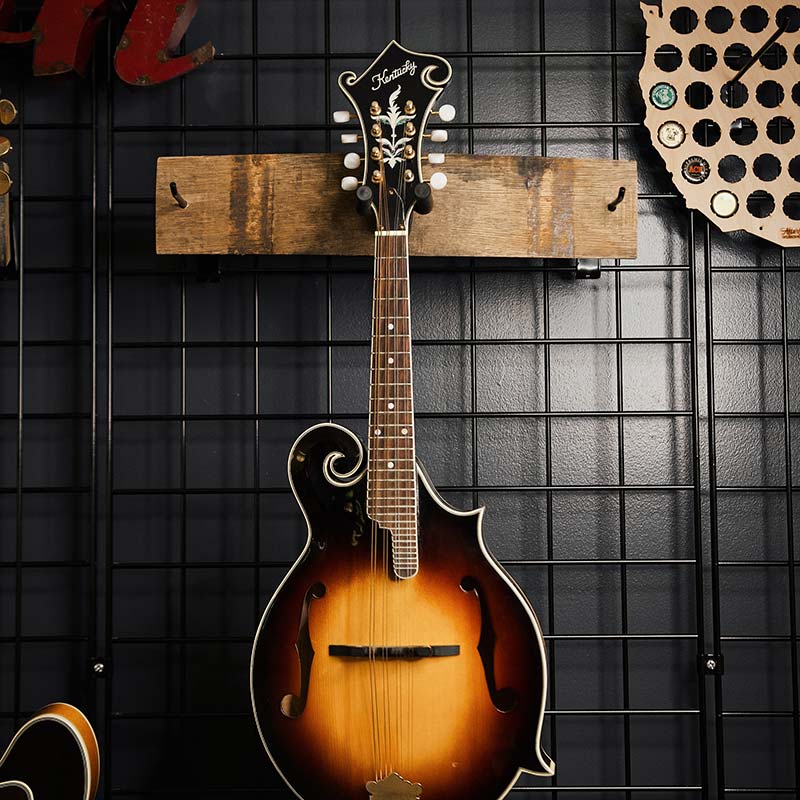 Barrel stave single guitar hanger on a wall holding a guitar
