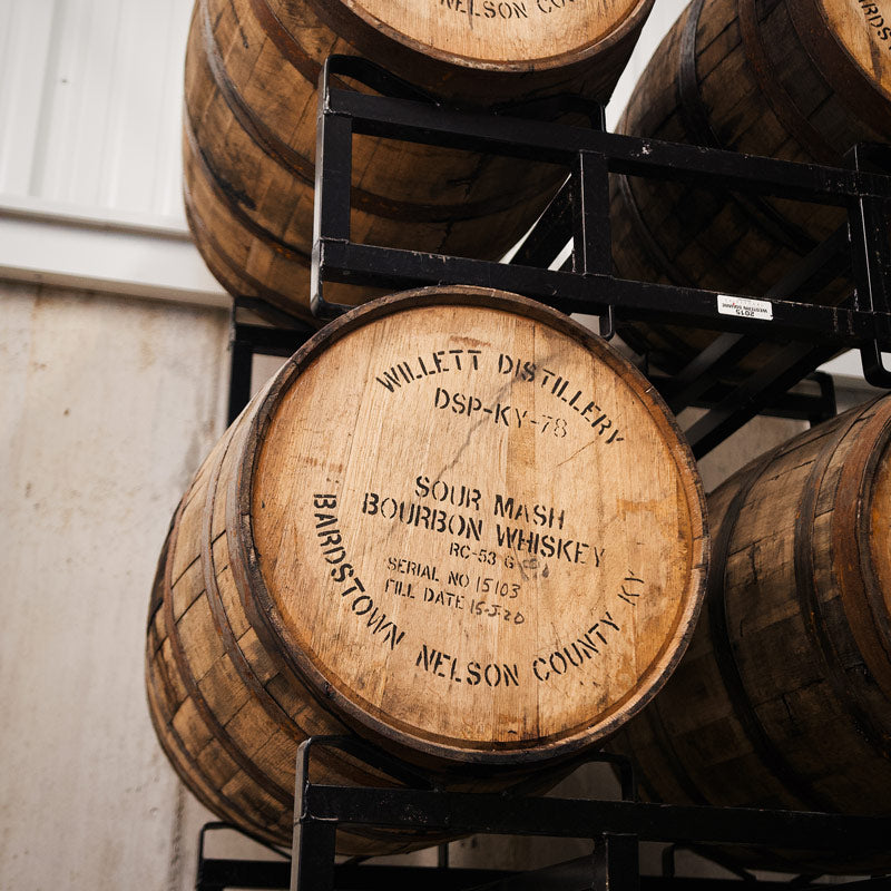 Willett Bourbon barrels on black steel racks