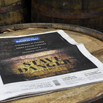 Louisville Business First newspaper with Stave Danger cover article laying on top of a bourbon barrel