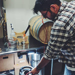 Ricky Cervantes transferring beer from a small barrel