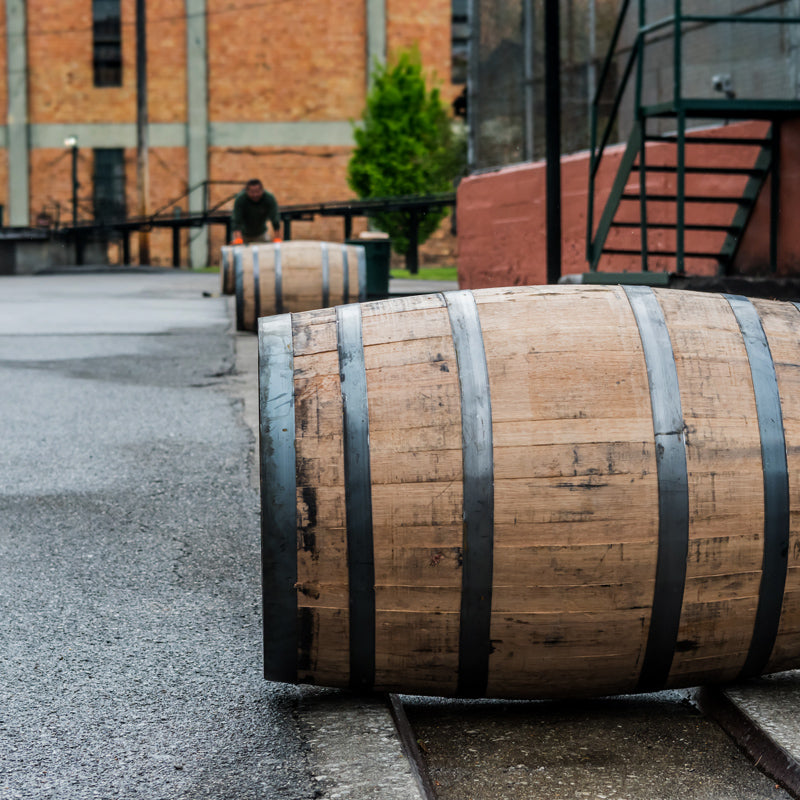 Whiskey barrels rolling on a track outside a rickhouse at a distillery