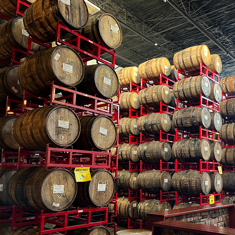 Racks of bourbon barrels aging beer in a brewery