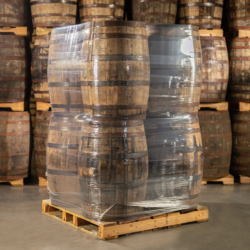 Used whiskey barrels for decor and furniture wrapped in plastic and loaded on a pallet