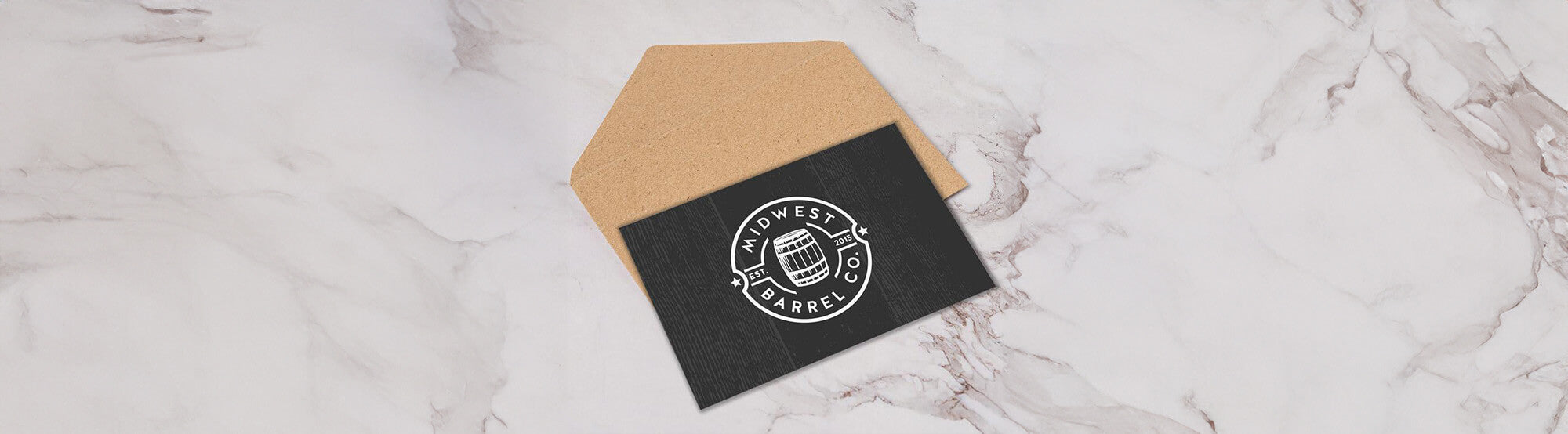 Midwest Barrel Co. gift card with barrel logo in center on top of an envelope