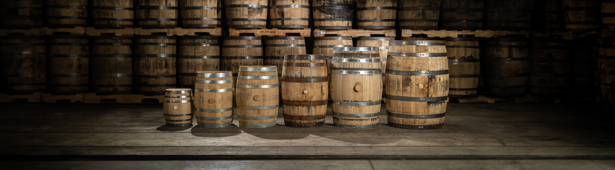 Different sizes of new and used oak aging barrels