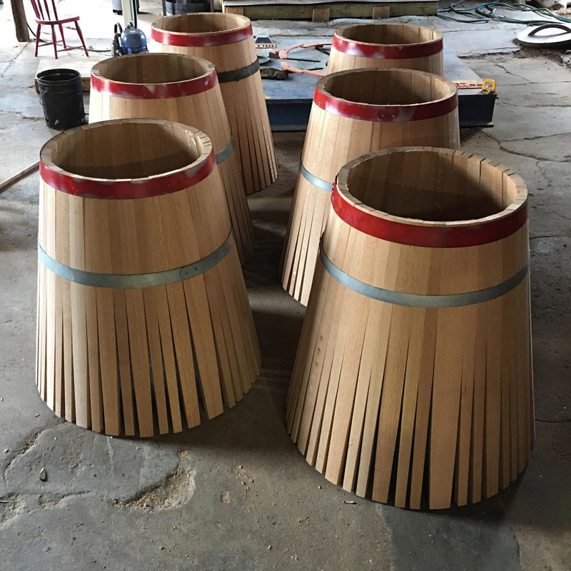 6 groups of American white oak staves being formed into a barrel with a steel ring