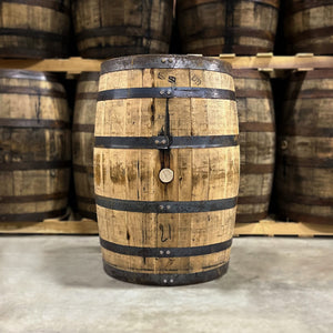 
                  
                    Side with bung of a 6 Year Austin Nichols Wild Turkey Bourbon Barrel with other used bourbon barrels stacked on pallets in the background
                  
                