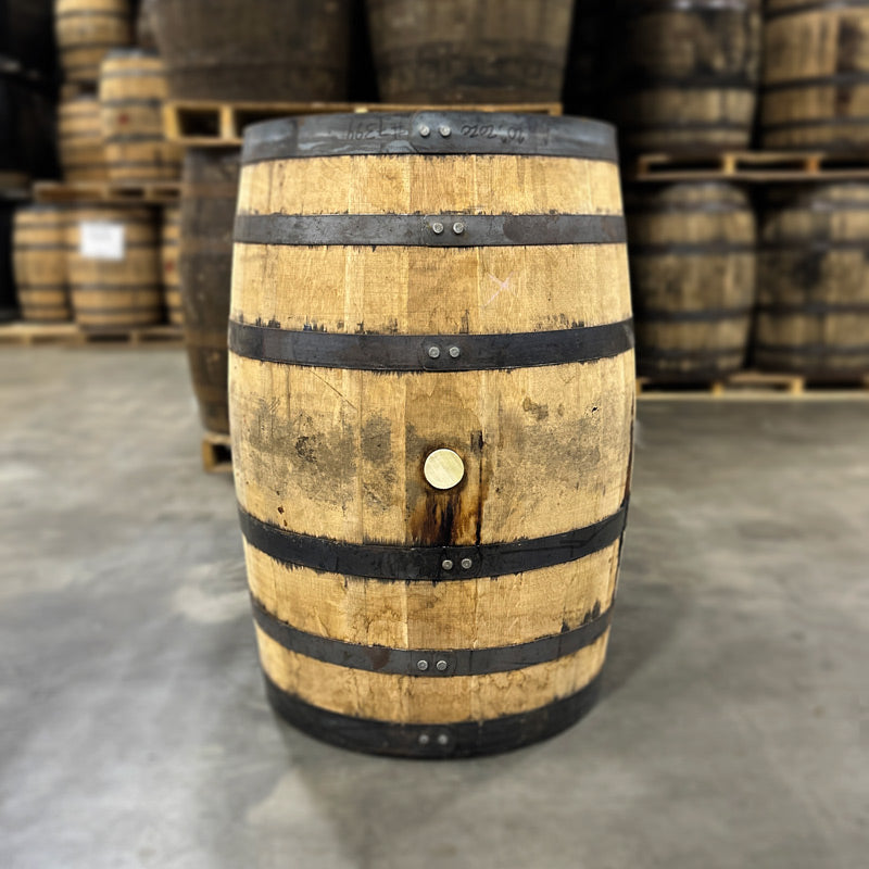 
                  
                    Bunghole side of a Kings County Bourbon Barrel with other used bourbon barrels stacked in the background
                  
                