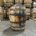 Bunghole side of a Starlight Bourbon Barrel and other used bourbon barrels stacked on pallets in the background