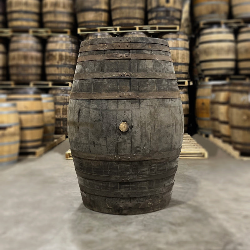 Side and head of a Templeton Rye Olroso Sherry Cask Finished Whiskey Barrel with other used whiskey barrels in the background