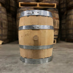 bunghole side of a 5 Gallon Journeyman Wheat Whiskey Barrel with other used whiskey barrels on pallets in background