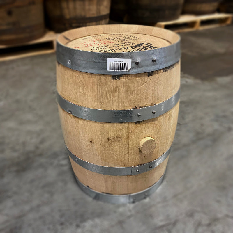 Head and side of a 5 gallon Journeyman Wheat Whiskey Barrel with other used whiskey barrels in the background