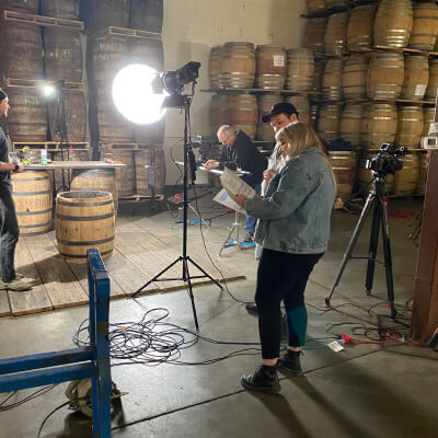 People working a barrel photo shoot in warehouse