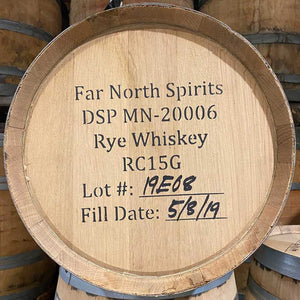 
                  
                    Head of a 23 Gallon Far North Spirits Rye Whiskey barrel with other used whiskey barrels in the background with Far North Spirits, distillery number, fill date and other information stamped on the head
                  
                