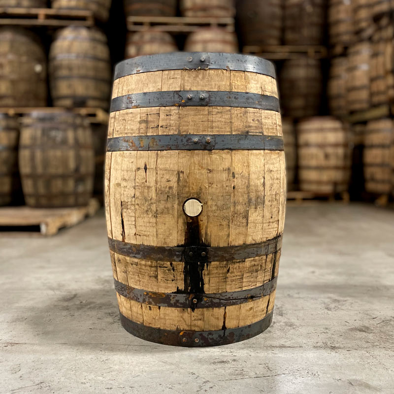
                  
                    Side of a Woodford Reserve Bourbon barrel with other used bourbon barrels in the background
                  
                