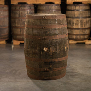 
                  
                    Side of a used Buffalo Trace Mash 1 Bourbon Barrel with other barrels stacked on pallets in the background
                  
                