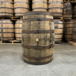 Side of a 15 Year Barton Distilling Co 1792 Bourbon Whiskey Barrel with other barrels stacked on pallets behind it