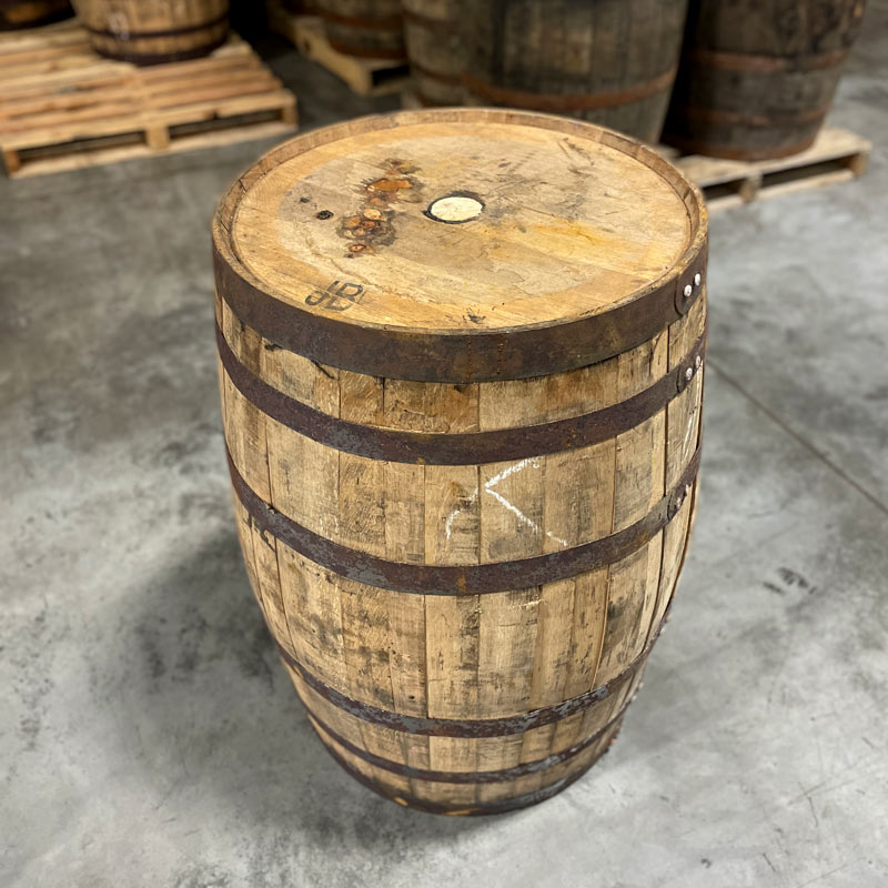 
                  
                    View of side and head of Templeton Rye Whiskey Barrel and barrels on pallets in the background
                  
                