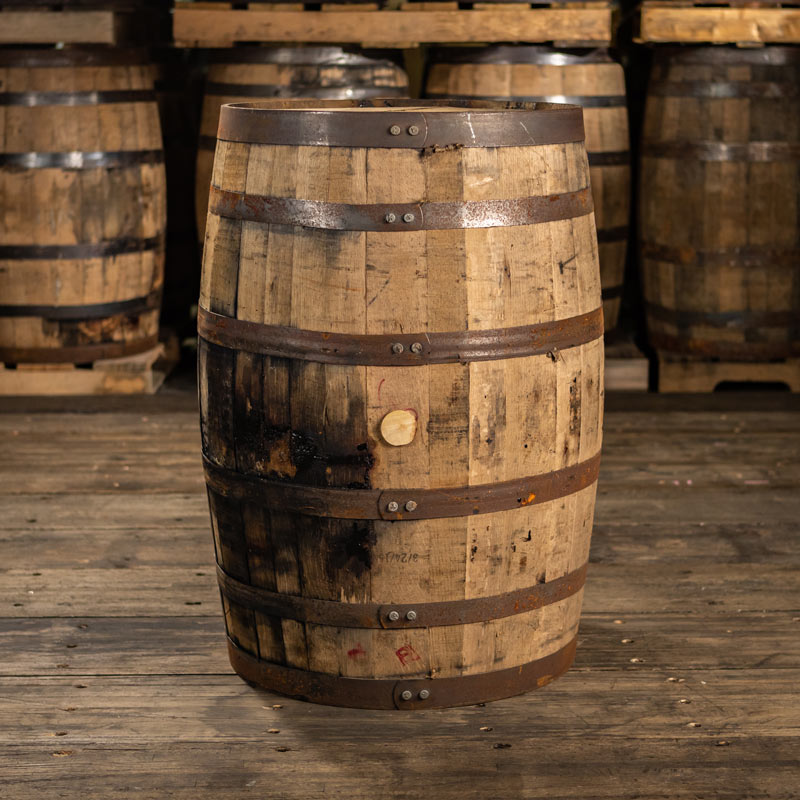 Side of a 10 Year Russell's Reserve Bourbon barrel with barrels stacked on pallets in the background