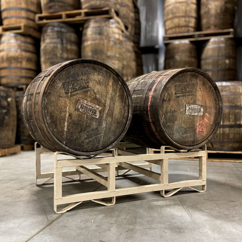 
                  
                    Two 15-Year Pappy Van Winkle Bourbon barrels on a rank with barrels stacked on pallets in the background
                  
                