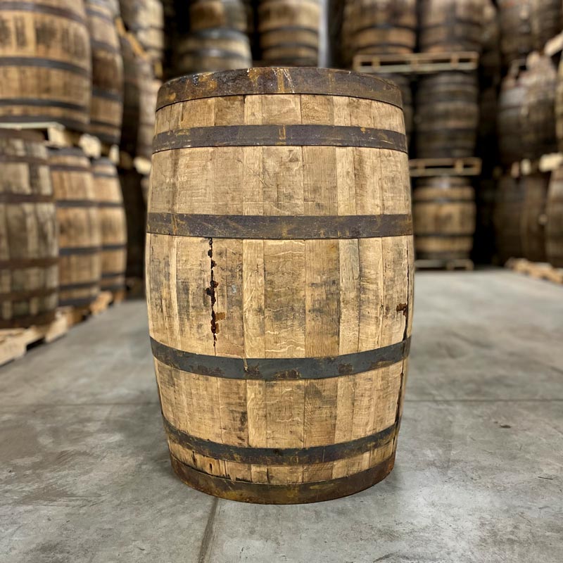 Side of an Old Elk Rye Whiskey Barrel with other barrels stacked on pallets in the background