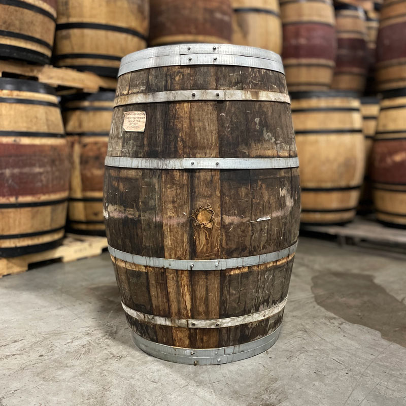 Side of a Breckenridge Distillery Cognac Finish Whiskey Barrel with other used barrels on pallets in the background