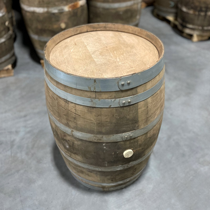 
                  
                    Unmarked head and side of a Jim Beam Wine Cask Finished Bourbon Barrel with other used wine barrels in the background
                  
                