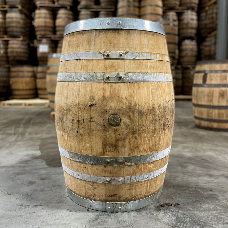 
                  
                    Side of a Head of a Lucky Seven Bourbon The Frenchman Cask Finish Barrel with other used barrels stacked on pallets in the background
                  
                