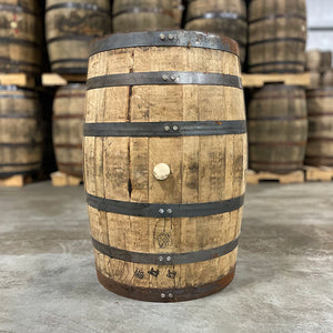 
                  
                    Side of a Straight Edge Bourbon barrel with other used bourbon and whiskey barrels stacked on pallets in the background
                  
                
