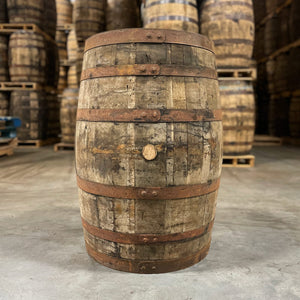 
                  
                    Side of an 18 Year Knob Creek Limited Edition Bourbon Barrel with other used bourbon barrels stacked on pallets in the background
                  
                