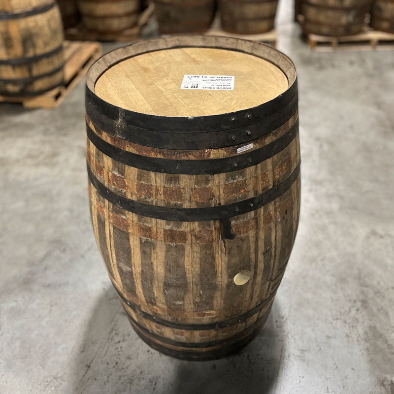 Head and side with bung of an Old Elk Oloroso Sherry Cask Finish Bourbon Barrel with other used barrels in the background