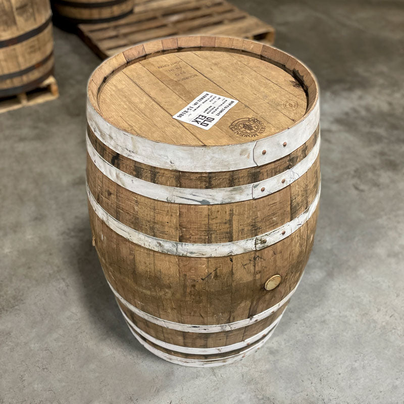 Side and head of an Old Elk Wheated Bourbon Light Char Barrel with an Old Elk distillery sticker and cooperage markings on the head