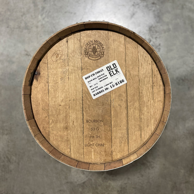 Head of an Old Elk Wheated Bourbon Light Char Barrel with an Old Elk distillery sticker and cooperage markings on the head