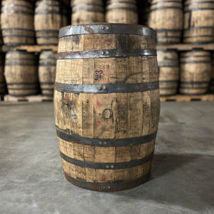 
                  
                    Bunghole side of a Kentucky Owl Bourbon Barrel with other used bourbon barrels stacked in the background
                  
                